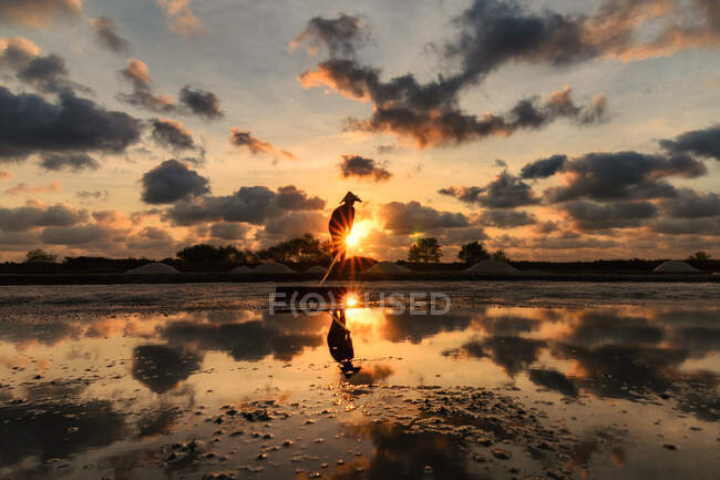Pôr do sol cênico sobre o lago com pescador — Fotografia de Stock