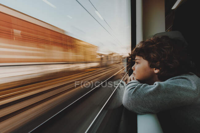 Rapaz a olhar através da janela do comboio — Fotografia de Stock