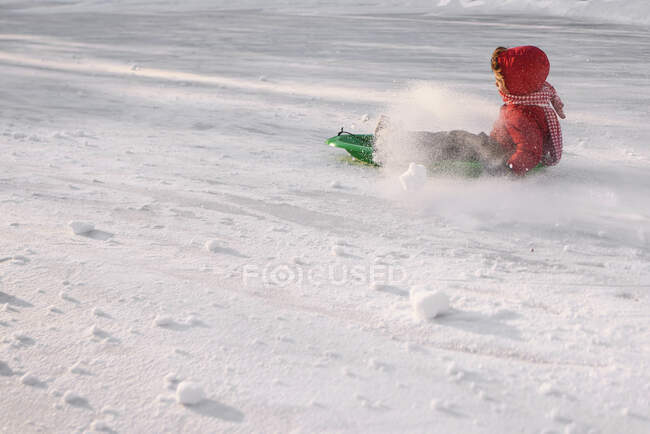 Мальчик катается на санках по снегу на природе — стоковое фото