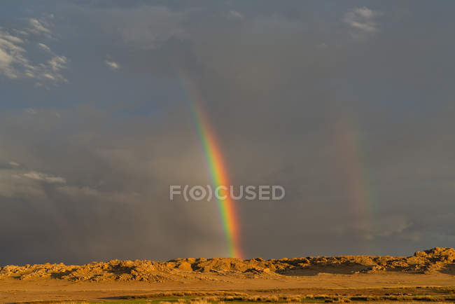 Nuvole di tempesta e un arcobaleno al tramonto, Baga Gazariin Chuluu, Mongolia — Foto stock