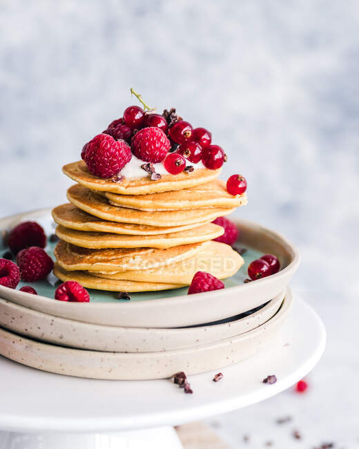 Stapel Pfannkuchen mit Joghurt, frischen Himbeeren und roten Johannisbeeren — Stockfoto