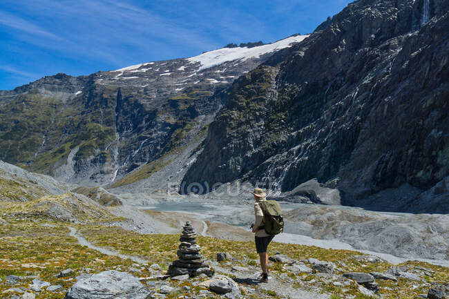 Homme passant devant un cairn sur la piste de selle Cascade, piste de Rees-Dart, parc national Mt Aspiring, île du Sud, Nouvelle-Zélande — Photo de stock