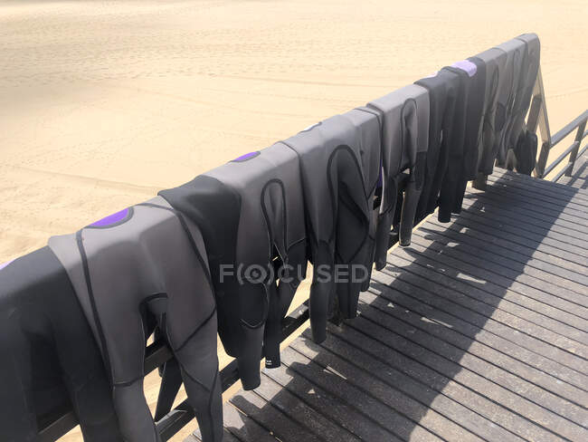 Combinaisons suspendues sur une jetée en bois à la plage, Portugal — Photo de stock