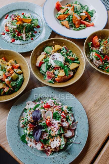 Seis saladas diferentes em uma mesa — Fotografia de Stock