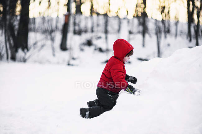 Boy playing in the snow outdoors — Stock Photo