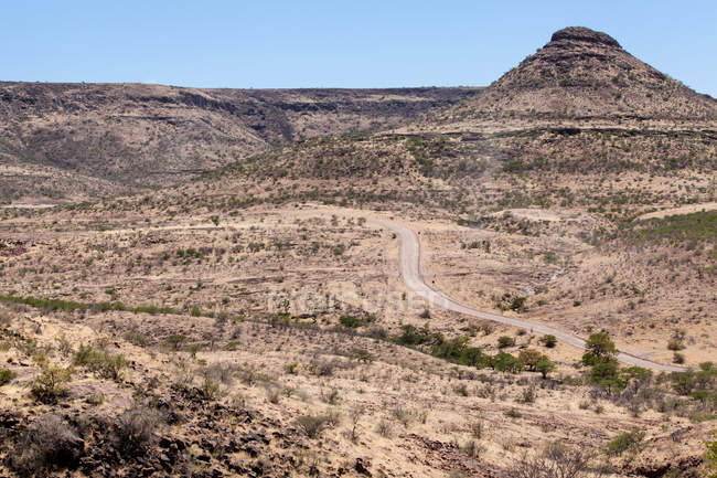 Vista panorámica de la carretera a través del paisaje del desierto, región de Kunene, Namibia - foto de stock