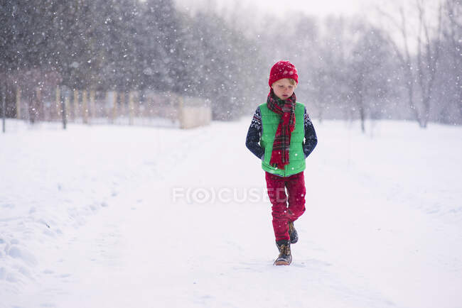 Хлопчик ходить снігом в зимовий день — стокове фото