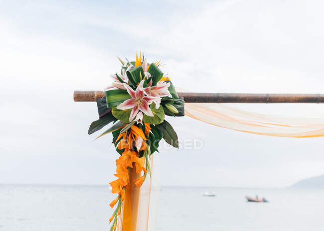 Primer plano del arco de la boda con flores en la playa - foto de stock