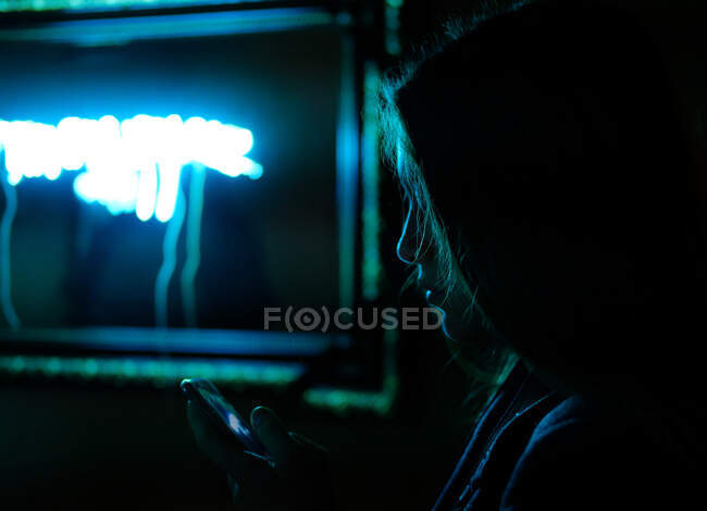 Silhouette d'une fille regardant un téléphone portable — Photo de stock