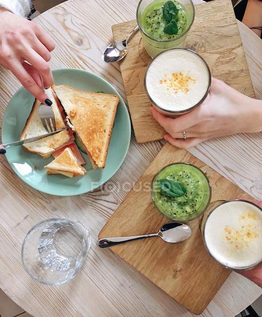 Dos mujeres desayunando juntas, cortadas - foto de stock