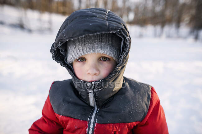 Portrait d'un garçon debout dans la neige — Photo de stock