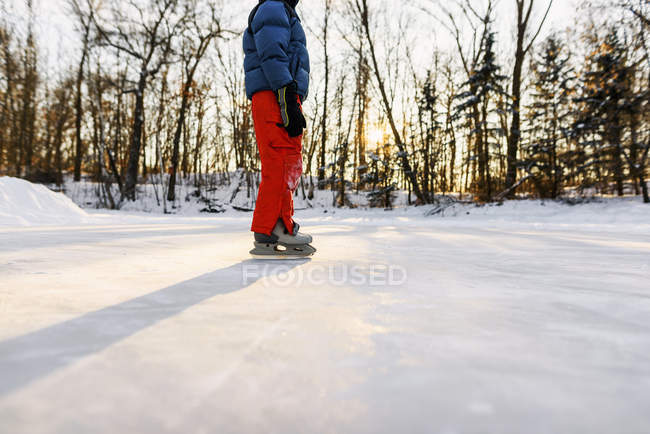 Хлопчик катається на замерзлому озері — стокове фото