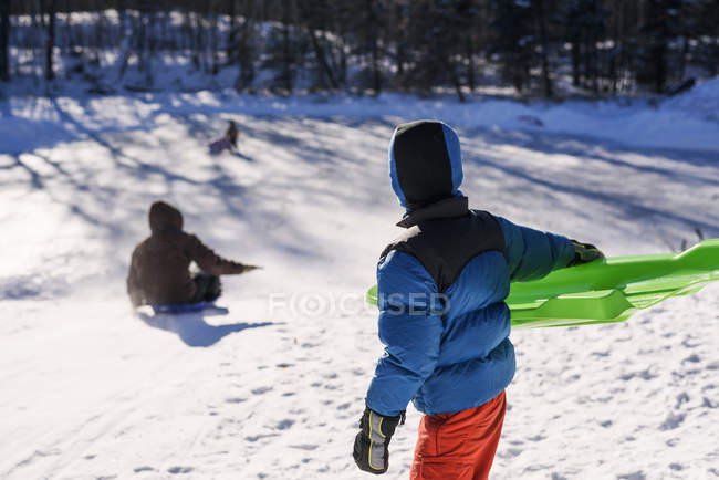 Хлопчик катається зі своєю матір'ю на зимовому снігу — стокове фото