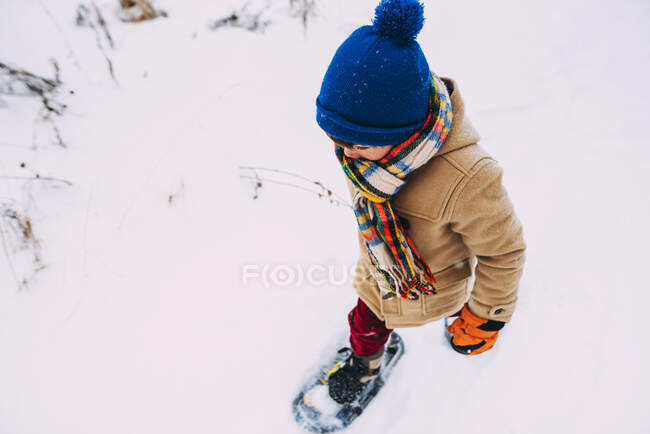 Junge läuft mit Schneeschuhen im Schnee — Stockfoto
