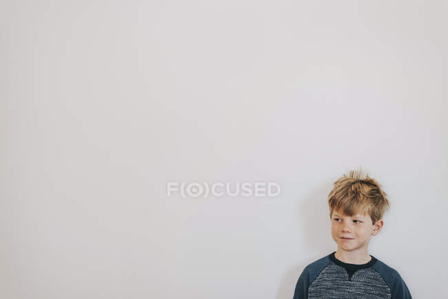 Retrato de un niño con pecas mirando hacia los lados - foto de stock