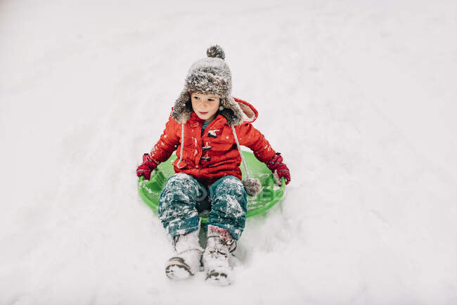 Menina jovem trenó na neve pesada — Fotografia de Stock