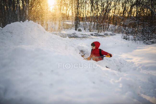 Chico paleando nieve en el jardín - foto de stock