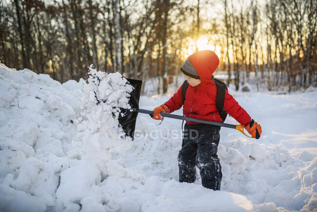 Menino limpando neve no jardim — Fotografia de Stock