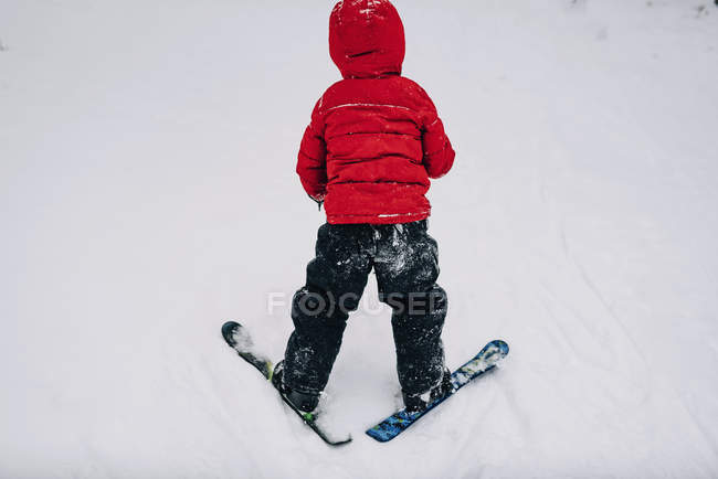 Rear view of a Boy doing a snowplough — Stock Photo