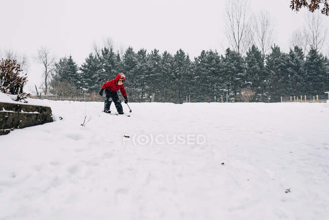Хлопчик катається на лижах у важкому снігу на природі — стокове фото