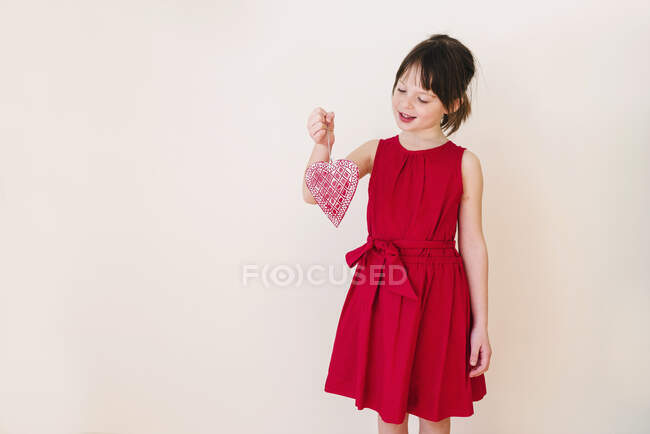 Smiling Girl holding a heart shape decoration — Stock Photo