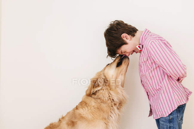 Boy cuddling his golden retriever dog — Stock Photo