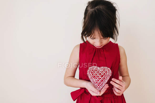 Ragazza che tiene una decorazione a forma di cuore — Foto stock