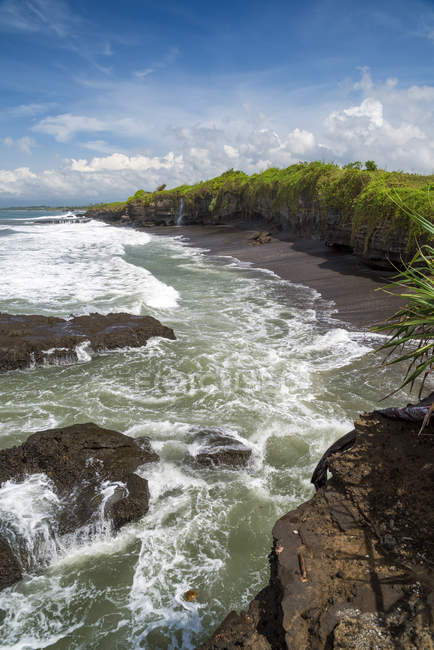 Vista panorámica de la costa de la playa rocosa cerca de Tanah Lot, Beraban, Bali, Indonesia - foto de stock