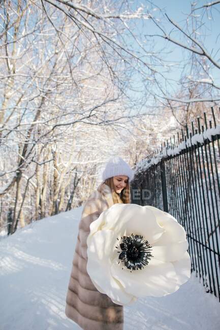 Woman holding a giant artificial anemone flower — Stock Photo