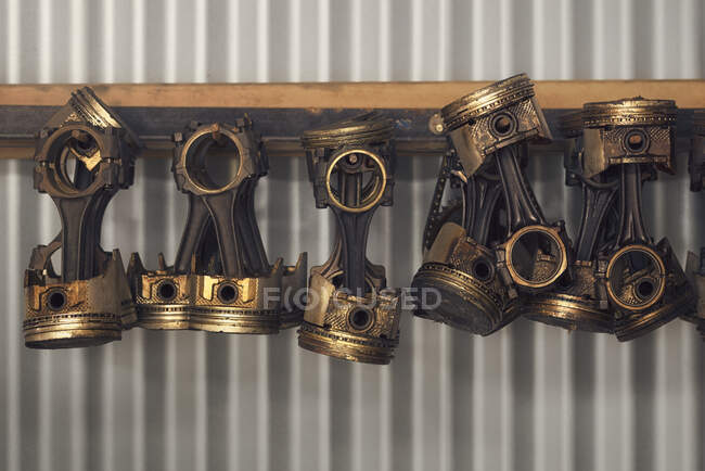 Vehicle pistons hanging from a corrugated shed wall — Stock Photo