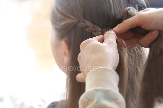 Grandmother braiding her granddaughters hair closeup — Stock Photo