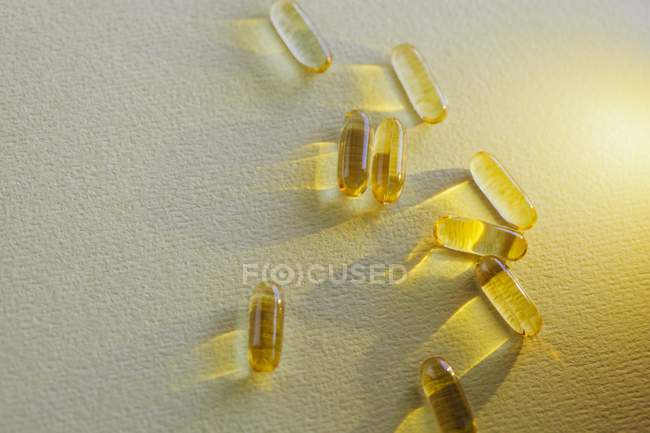 Vue surélevée des capsules jaunes sur la table — Photo de stock
