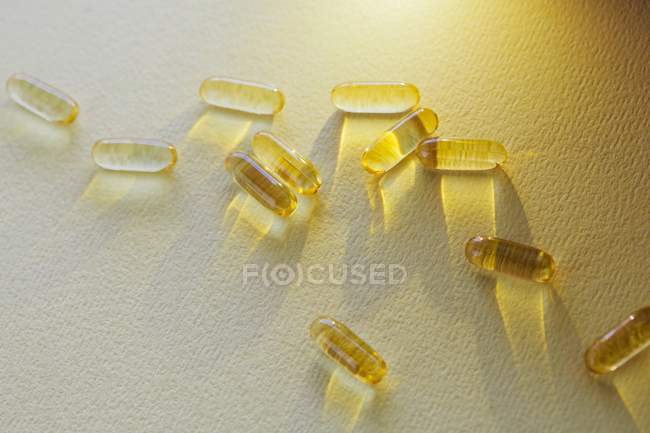 Vue surélevée des capsules jaunes sur la table — Photo de stock
