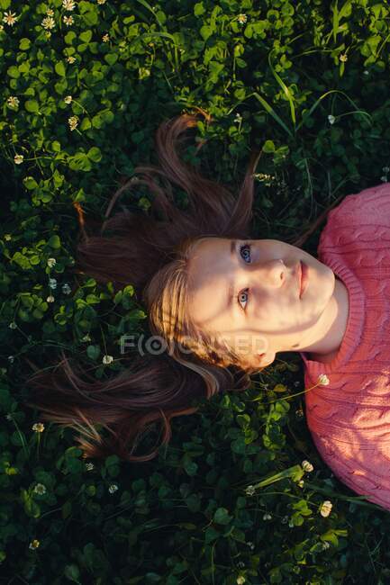 Smiling girl lying in a meadow — Stock Photo