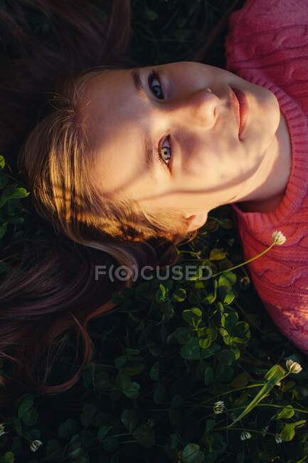 Sonriente chica acostada en un prado - foto de stock