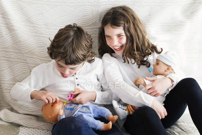 Menino e menina brincando com bonecas — Fotografia de Stock