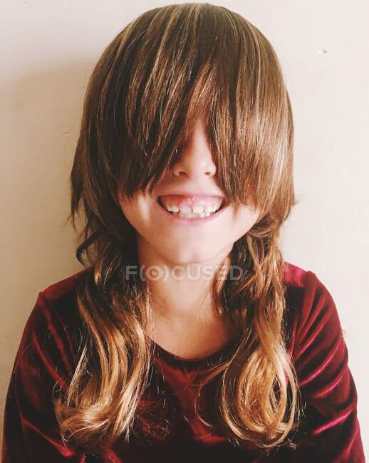 Retrato de uma menina sorridente com franja cobrindo os olhos — Fotografia de Stock