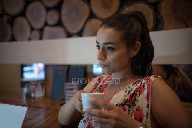 Woman enjoying a cup of coffee in restaurant — Stock Photo