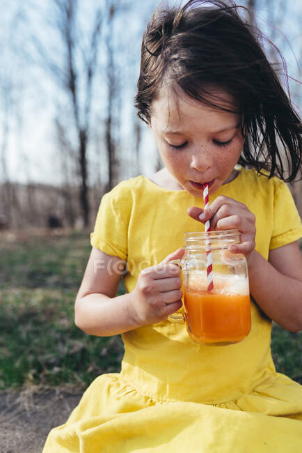 Девушка наслаждается летним напитком на природе — стоковое фото