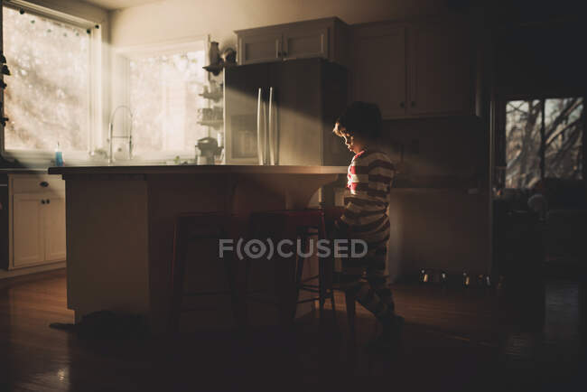 Niño de pie en la cocina bailando - foto de stock