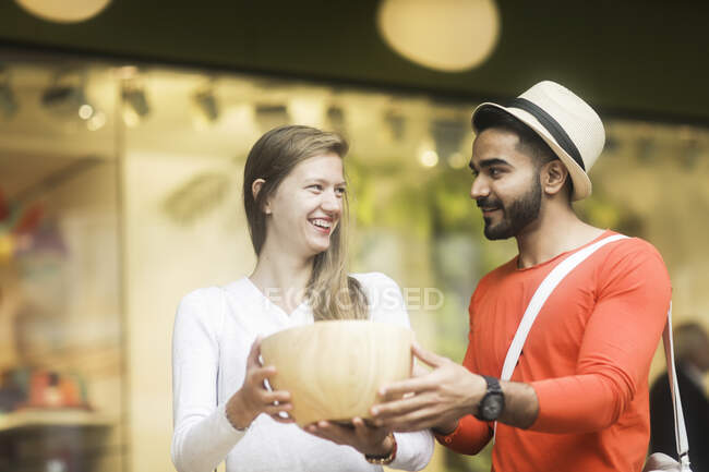 Smiling couple shopping for a wooden bowl — Stock Photo