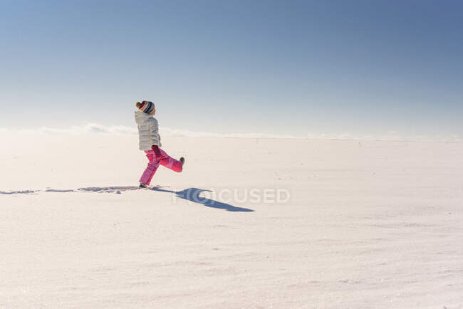Girl playing in a snowy rural landscape — Stock Photo