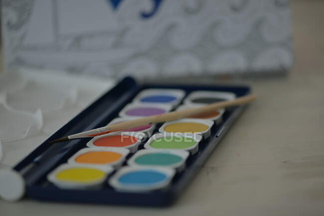 Close-up of watercolor paints and a paintbrush — Stock Photo
