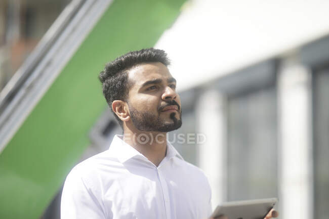 Man standing outdoors using a digital tablet — Stock Photo