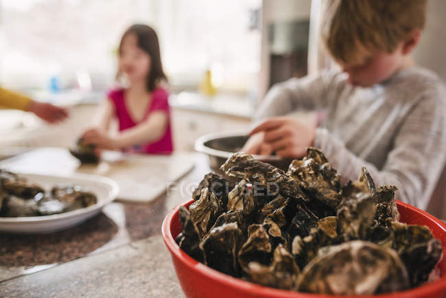 Brother and sister preparing fresh oysters — Stock Photo