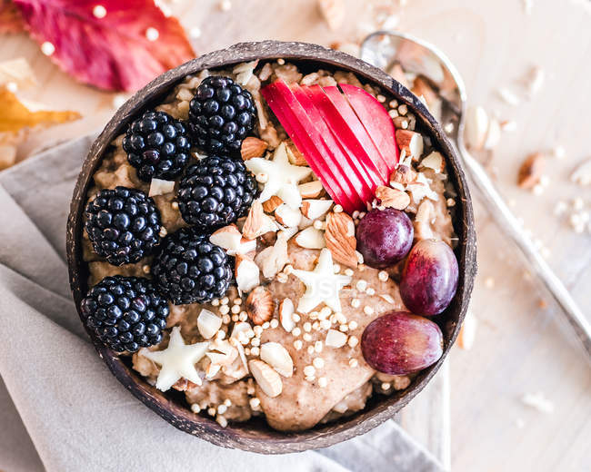 Oatmeal bowl with blackberries, grapes, apple and nuts — Stock Photo