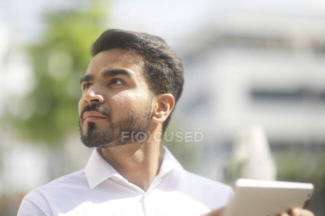 Man standing outdoors using a digital tablet — Stock Photo