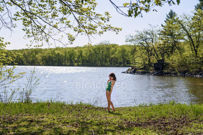 Mädchen steht im Badeanzug am See — Stockfoto