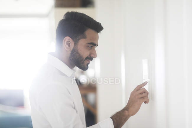Man setting a digital control on a wall — Stock Photo