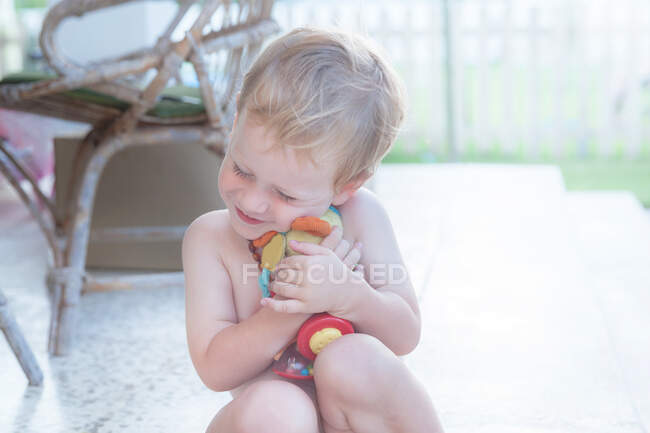 Усміхнений хлопчик придушує м'яку іграшку — стокове фото
